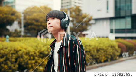 Man, headphones and student travel in city, streaming playlist and online for listening to song. Male person, university campus and hearing sound on journey in Japan, trip and commute to lecture 120922686