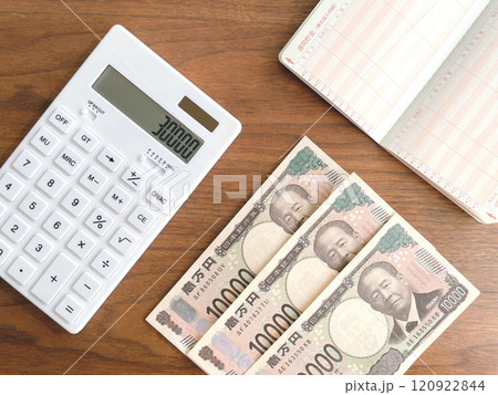 机上に置いた3万円と電卓と通帳 120922844