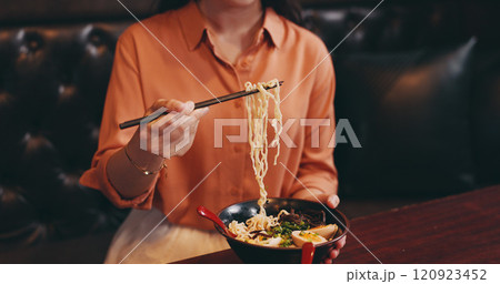 Hands, woman and eating lunch as hungry in restaurant for nutrition, culture and healthy meal. Female person, hospitality and diet with traditional cuisine, chopsticks and ramen noodles as asian food Hands, woman and eating lunch as hungry in restaurant for nutrition, culture and healthy meal. Female person, hospitality and diet with traditional cuisine, chopsticks and ramen noodles as asian food 120923452