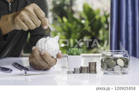 Hand with money coins in clear glass, Business investment growth concept, saving concept, Hand putting coin in clear jar. Hand with money coins in clear glass, Business investment growth concept, saving concept, Hand putting coin in clear jar. 120925858