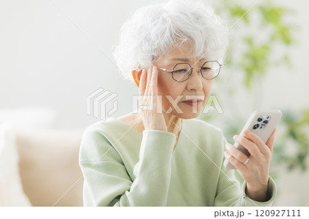 リビングで電話するシニア女性　 120927111