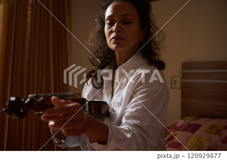 Woman practicing violin in a warmly lit bedroom setting 120929877
