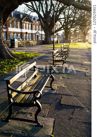 明るい夜明けの朝日を浴びるテームズ川沿いの公園に置かれた歴史的なベンチ　ロンドン郊外のキューにて 120929901