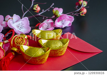 Golden Ingots on top of Chinese New Year red packet. Chinese New Year celebration 120930816