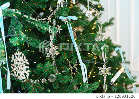 Christmas tree branches adorned with glass ornaments and ribbons on white plaster wall background 120931326