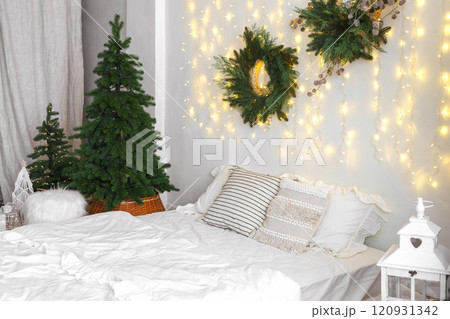 Christmas tree and wreath in bedroom, holiday decor and warm lighting during winter months 120931342