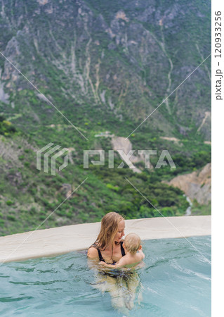 Mother with her toddler son bathing in the hot springs of Grutas Tolantongo, Mexico. Family adventure, relaxation, and natural wellness concept 120933256