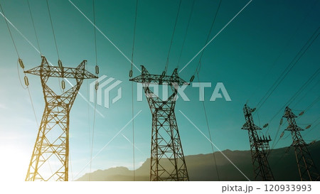 Silhouettes of a power pylons set against the backdrop of the French Alps. Grenoble, France 120933993