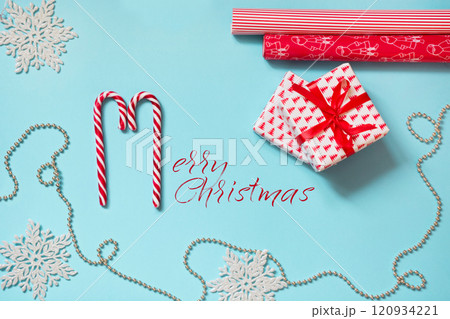 Christmas creative workplace with gift, snowflakes red paper on blue. Xmas card. 120934221