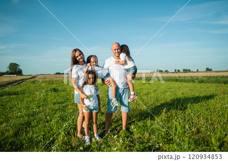 The family spends leisure time in the fresh air.Three sisters are playing in nature in the grass. 120934853