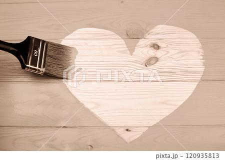 Heart shape painted on wooden surface with a large brush, symbolizing creativity 120935813