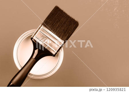 Paintbrush resting on a can with a warm, elegant tone background 120935821