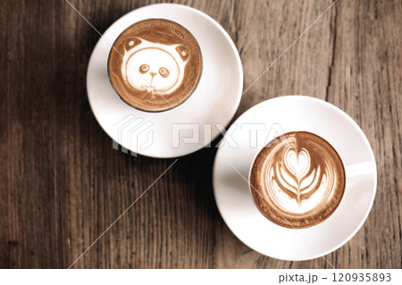 Latte art featuring a panda and leaf design on wooden table surface Latte art featuring a panda and leaf design on wooden table surface 120935893