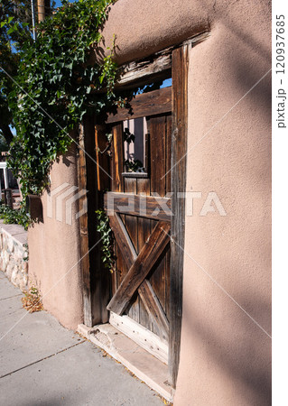 Old wooden garden door of an adobe house in Santa  120937685