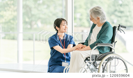 介護施設・病院で働く看護師・介護福祉士・理学療法士・作業療法士・言語聴覚士と高齢者・シニア女性 120939604