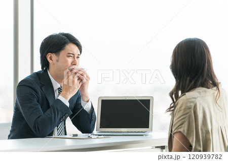 弁護士事務所・個別相談会でトラブルの相談をする相談者女性と男性弁護士・相談員（落ち込む・困る・悩む） 120939782