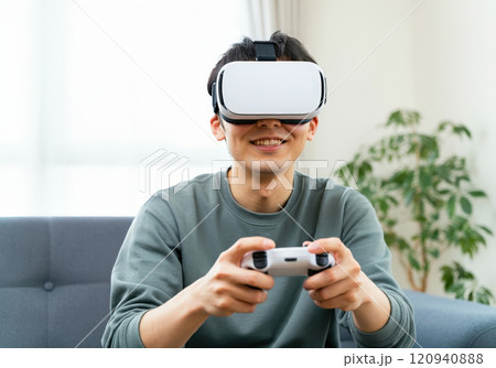 自宅でVRゲームに興じる若い男性 120940888