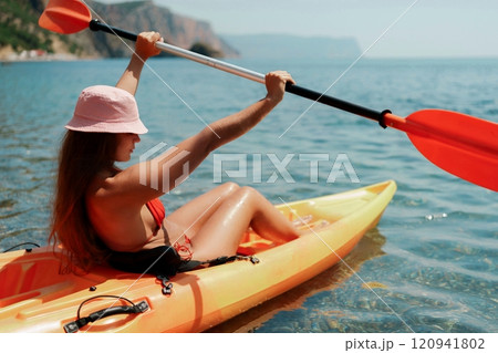 Kayak sea woman. Happy attractive woman with long hair in red swimsuit, swimming on kayak. Summer holiday vacation and travel concept. 120941802