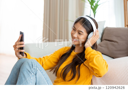 Happy young asian woman relaxing at home Happy young asian woman relaxing at home 120942626