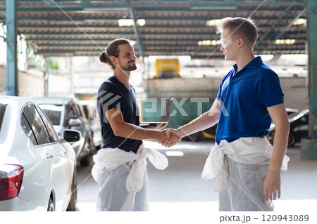 Team of professional automotive painting technician in chemical protecting suit standing in front of the painting chamber together. Car painting and detailing technicians portrait. Team of professional automotive painting technician in chemical protecting suit standing in front of the painting chamber together. Car painting and detailing technicians portrait. 120943089