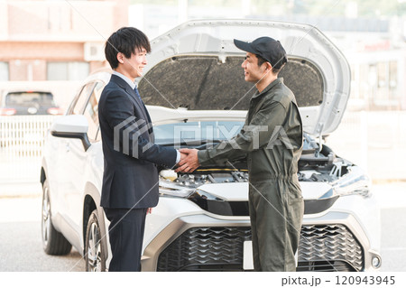 ロードサービスを受けて整備士と握手するドライバーの若い男性 ロードサービスを受けて整備士と握手するドライバーの若い男性 120943945