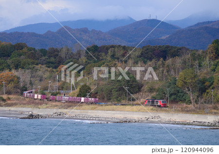 小さな峠を越えて有珠の海岸線を札幌へ目指す貨物列車 120944096