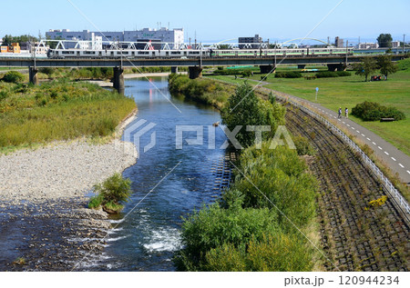 豊平川橋梁を渡る721系と735系併結の普通列車 120944234