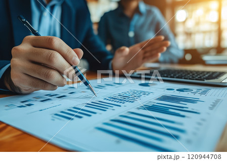 Business professionals analyzing financial charts and data with pen and laptop 120944708