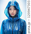 雨の中でレインコート着て立っている東洋系の女性 120947303