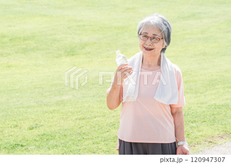 公園で散歩・ウォーキング中に深呼吸するシニア女性 120947307
