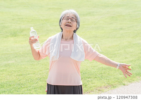 公園で散歩・ウォーキング中に深呼吸するシニア女性 120947308