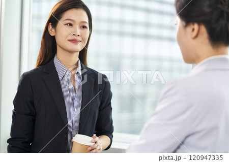 young asian businesswomen chatting in office young asian businesswomen chatting in office 120947335
