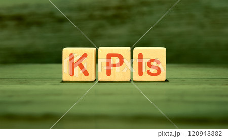 Business strategists. Copy space. The abbreviation KPIs It is written on wooden cubes on a green background Business strategists. Copy space. The abbreviation KPIs It is written on wooden cubes on a green background 120948882