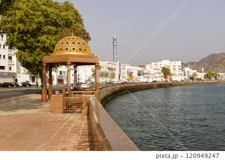 Golden ornated dome gazebo in traditional Omani style with port and cruise ships in the background, 120949247