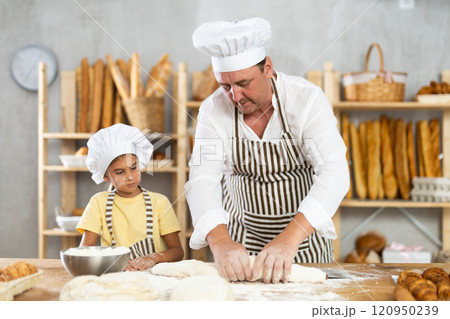 Father and daughter roll out dough together to make delicious bread Father and daughter roll out dough together to make delicious bread 120950239
