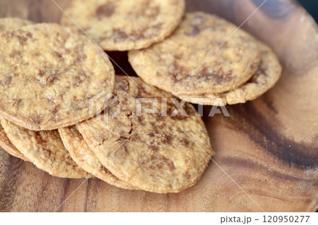 アカシアプレートの上の薄焼きタイプのぬれ煎餅 120950277