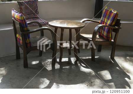 Two wooden chairs with seat cushion and Rouhd table in Relaxing corner on morning sun. Two wooden chairs with seat cushion and Rouhd table in Relaxing corner on morning sun. 120951100