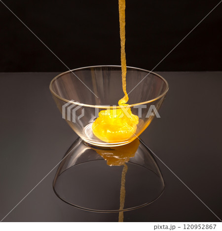 Fresh floral honey flows into a transparent plate in a mirror image. Organic Vitamin Health Food Fresh floral honey flows into a transparent plate in a mirror image. Organic Vitamin Health Food 120952867