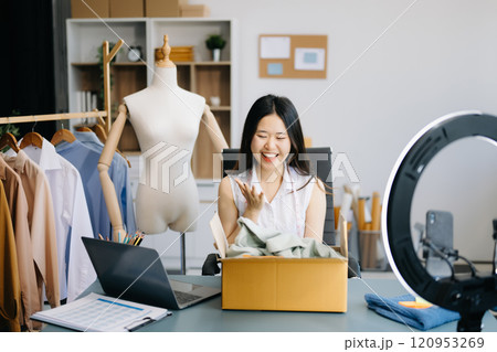 Fashion blogger concept, Young women selling clothes on video streaming.Startup small business SME, using smartphone or tablet taking receive and checking Fashion blogger concept, Young women selling clothes on video streaming.Startup small business SME, using smartphone or tablet taking receive and checking 120953269