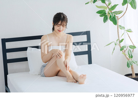 ベッドで脚のスキンケアをする女性 120956977
