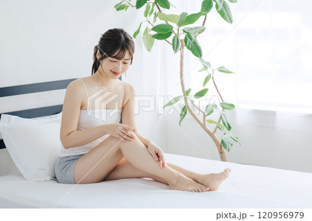 ベッドで脚のスキンケアをする女性 ベッドで脚のスキンケアをする女性 120956979