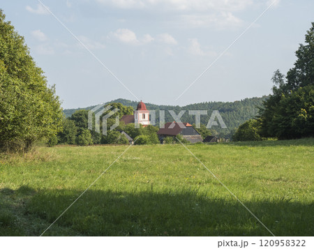 Summer view of old historical Bohemian village Zdirec Borejov with Church of St. James in in Baroque architectural style and green meadow and trees, Kokorin region, central Bohemia 120958322