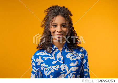 Young Charming African Woman With Kind Smile Looking To Camera On Yellow Studio Young Charming African Woman With Kind Smile Looking To Camera On Yellow Studio 120958734