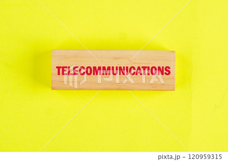 Wooden block with telecommunications written in bold red letters on a vibrant yellow background highlighting essential industry terminology Wooden block with telecommunications written in bold red letters on a vibrant yellow background highlighting essential industry terminology 120959315