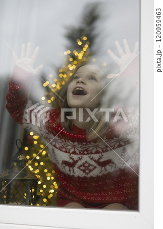 The girl in the window is waiting for a miracle. Christmas. 120959463