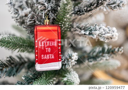 A close-up of a letters to santa text toy on a Christmas tree with lights on background A close-up of a letters to santa text toy on a Christmas tree with lights on background 120959477