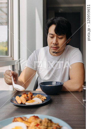 Happy man is having breakfast in the hotel dinning room. Happy man is having breakfast in the hotel dinning room. 120959651