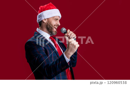 christmas event host man singing in santa hat, copy space. event host man singing with microphone 120960538