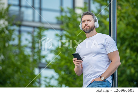 man choosing music playlist outside, advertisement. photo of man choose music playlist man choosing music playlist outside, advertisement. photo of man choose music playlist 120960603