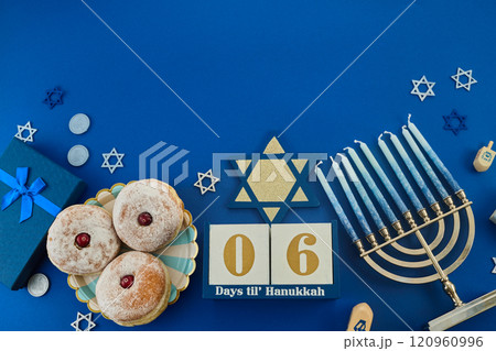 Jewish holiday Hanukkah concept. Frame of traditional jelly donuts and menorah on dark blue background 120960996